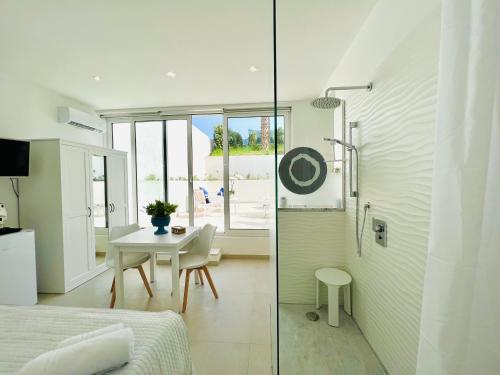 a bedroom with a shower and a table in a room at Torre Pozzillo Beach in Cinisi