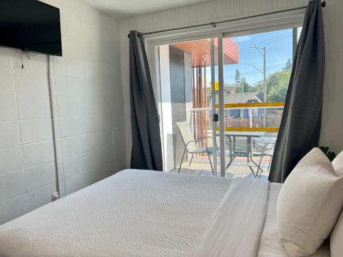 a bedroom with a bed and a door to a patio at The Spot in Nanaimo