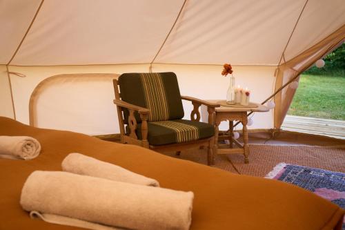 Zimmer mit einem Stuhl und einem Tisch in einem Zelt in der Unterkunft Hesselgaard Glamping in Dalby