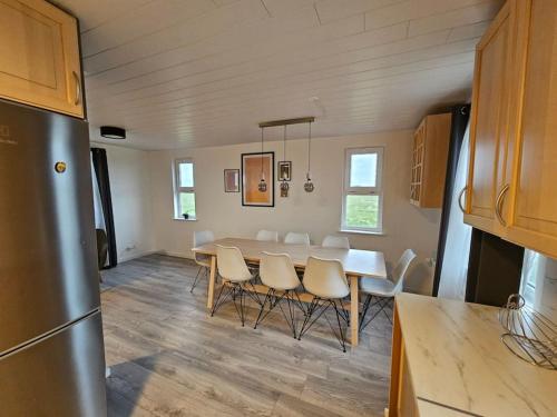 a kitchen and dining room with a table and chairs at VOT Vacation Homes-Akurhús in Gardur