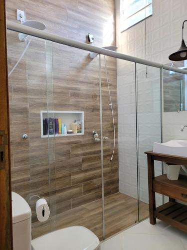 a bathroom with a shower with a toilet and a sink at Charmosa chácara do Broa! in Itirapina