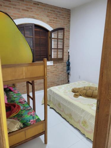 Cette chambre comprend 2 lits superposés et un mur en briques. dans l'établissement Charmosa chácara do Broa!, à Itirapina