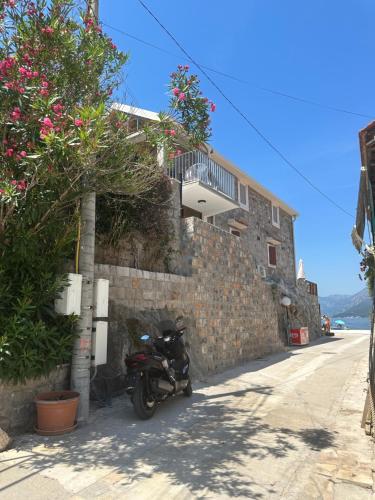 une moto garée sur le côté d'un bâtiment dans l'établissement Sapore Di Mare Apartment, à Tivat