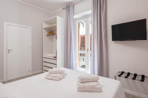 a white bedroom with a bed with towels on it at LE PORTE DEL KASSARO in Palermo