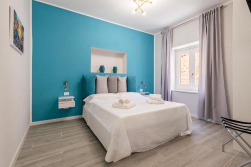 Dormitorio azul con cama blanca y pared azul en LE PORTE DEL KASSARO, en Palermo