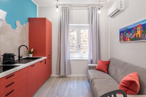 a living room with a couch and a kitchen at LE PORTE DEL KASSARO in Palermo
