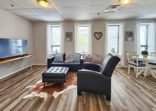 a living room with a couch and chairs and a tv at Modern and chic home with fine furnishing in Springfield