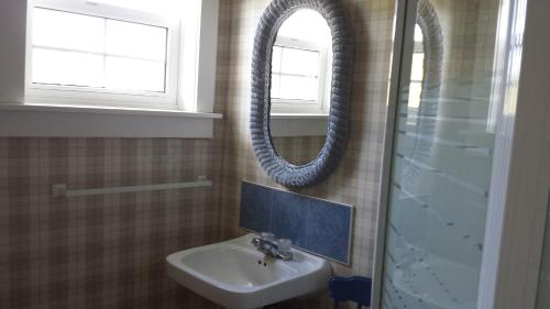 a bathroom with a sink and a mirror at Compass Rose Heritage Inn in North Head