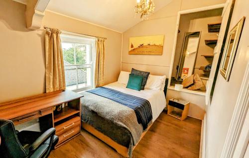 a small bedroom with a bed and a window at Cotswold VIP Regency Lodge in Cheltenham