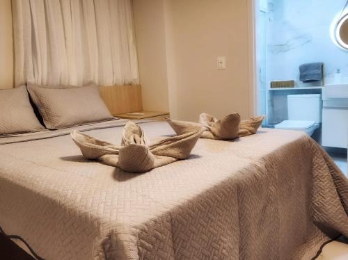 Un dormitorio con una cama con almohadas encima. en Sonho de apartamento pé na areia, en Porto de Galinhas