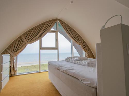a bedroom with a bed with a large window at De Garnaal in Egmond aan Zee