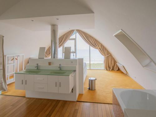 - une salle de bains avec lavabo dans une chambre dotée d'une fenêtre dans l'établissement De Garnaal, à Egmond aan Zee