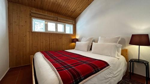 a bedroom with a bed with a red and white blanket at Arrayanes Royal in Sierra Nevada