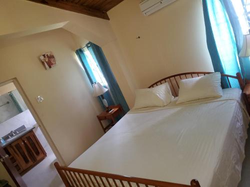 a bedroom with a bed with white sheets and pillows at Alian's Comfort Stay in Montego Bay