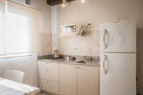 a kitchen with a white refrigerator and a sink at Tempo Apartamento in Villa Allende