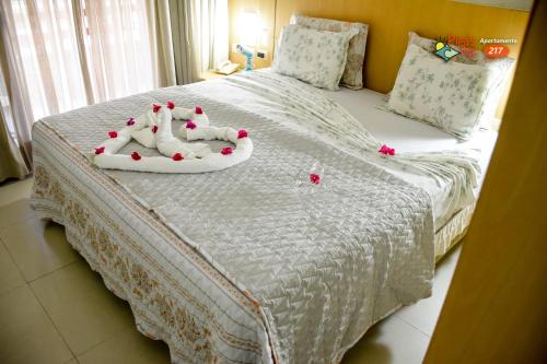 a white bed with red hearts on it at Flat no UNICO HOTEL BEIRA MAR Pipas Bay 217 in Pipa