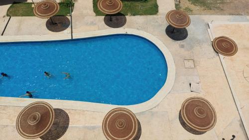 an overhead view of a swimming pool with people swimming at شاليه ديمورا عائلات فقط Dimora Chalet Only Family in Dawwār Muḩammad Abū Shunaynah