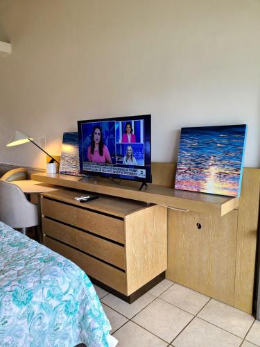 a room with a television on a wooden desk at Boundless Bliss Hotel in St Thomas