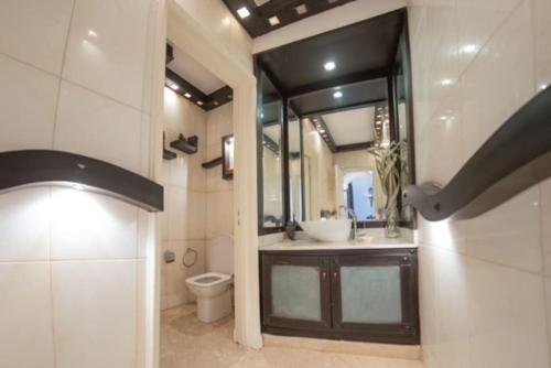 a bathroom with a sink and a toilet and a mirror at Bord de mer, villa de luxe in Tamaris