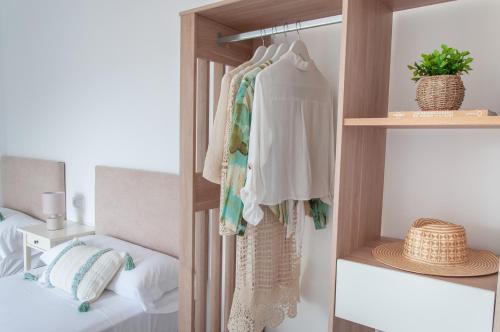 a bedroom with a closet with white clothes and a bed at Ítaca Apartment Peñiscola in Peñíscola