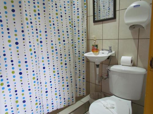 a bathroom with a toilet and a sink at Hostel Shakti in San José