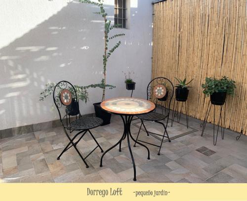 una mesa y cuatro sillas en un patio con plantas en Dorrego Loft en Barraquero