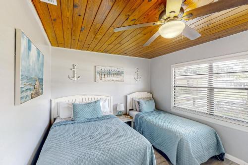 2 Betten in einem Schlafzimmer mit Deckenventilator in der Unterkunft Lake June Resort #9 in Lake Placid