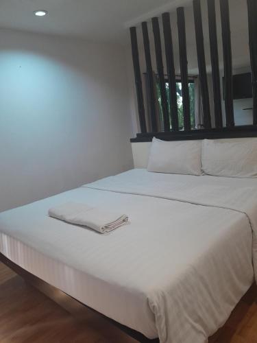 a white bed with a white towel on it at Zen Hotel @18 in Bangkok