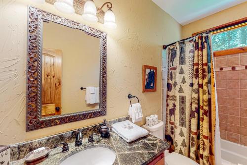 y baño con lavabo y espejo. en Whispering Creek, en Sapphire