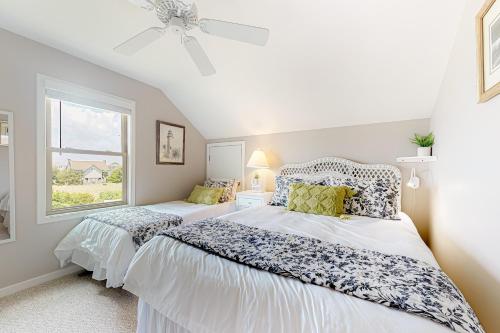 a bedroom with two beds and a window at Compass Rose in Topsail Beach