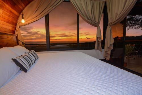 a bedroom with a bed with a view of a sunset at Casa Zafiro in Monteverde Costa Rica