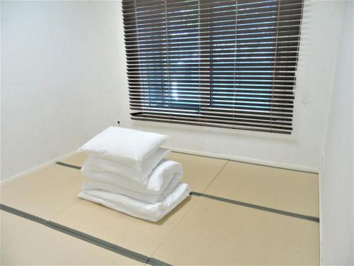 a stack of white towels sitting on the floor in a room at Healthcare Town Resort in Seogwipo