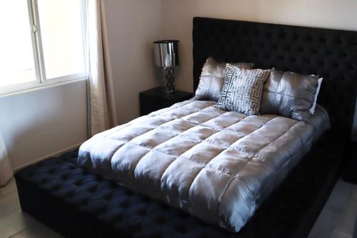 ein großes Bett in einem Zimmer mit einem großen Bettröckchen-Speckspeck in der Unterkunft Riviera De Rosarito in Rosarito