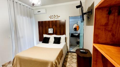 a hotel room with a bed and a wooden headboard at Pousada Nascente do São Francisco in Vargem Bonita