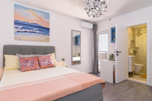 a bedroom with a large bed and a chandelier at Villa Del Mar Omiš in Omiš