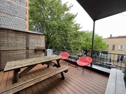 a wooden deck with a picnic table and two chairs at Le Bed & Cocktail - Appartement sur l'Avenue du Mont-Royal in Montréal