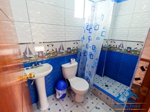 a blue and white bathroom with a toilet and a sink at Hotel Chota Golf in Chota