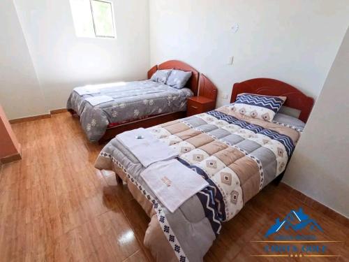 2 letti in una camera con pavimenti in legno di Hotel Chota Golf a Chota