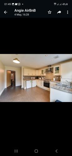 eine große Küche mit weißen Geräten und ein großes Zimmer in der Unterkunft Simitach Serviced apartments in Middleton