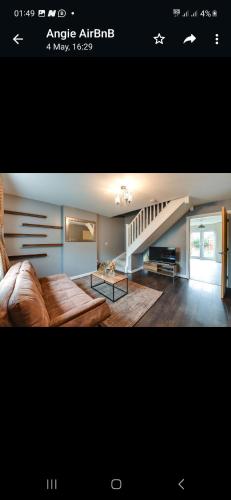ein Wohnzimmer mit einem Sofa und einer Treppe in der Unterkunft Simitach Serviced apartments in Middleton