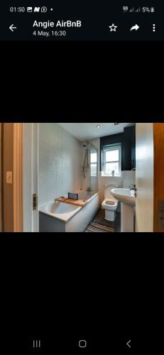 ein Badezimmer mit einer Badewanne, einem Waschbecken und einem WC in der Unterkunft Simitach Serviced apartments in Middleton