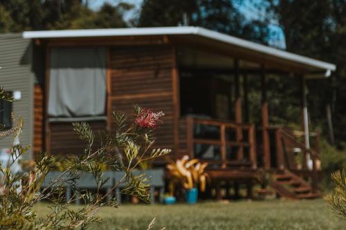 a log cabin with a large screened in porch at Blackwattle Farm in Beerwah