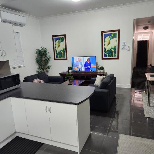 eine Küche und ein Wohnzimmer mit einem Sofa und einem Tisch in der Unterkunft City Villa 39 Blende st Broken Hill NSW 2880 in Broken Hill