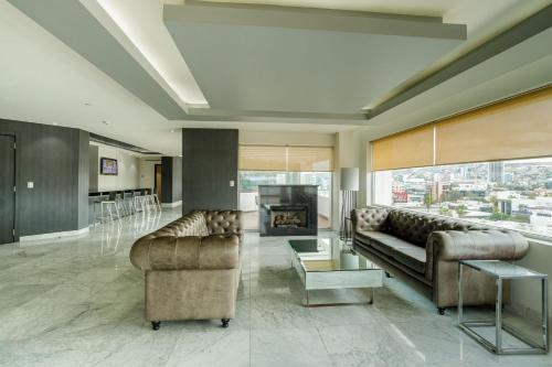 a living room with two couches and a fireplace at Real Inn Tijuana by Camino Real Hoteles in Tijuana