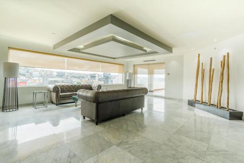 a large living room with a couch and a large window at Real Inn Tijuana by Camino Real Hoteles in Tijuana