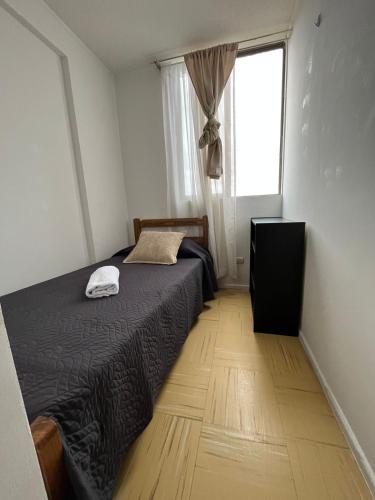a small bedroom with a bed and a window at Departamento equipado 348 Ovalle in Ovalle