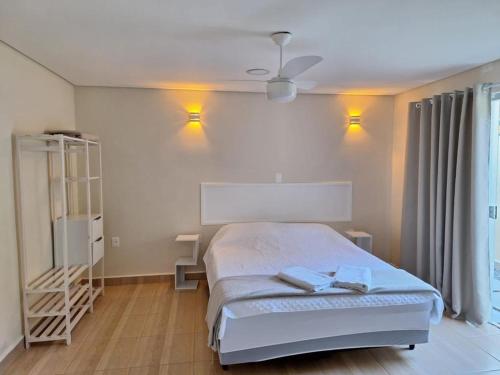 een slaapkamer met een bed en een plafondventilator bij Pousada Saint James in Águas de Lindóia