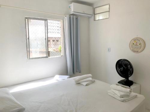 um quarto branco com uma cama e uma janela em Casa Brisa em Fortaleza