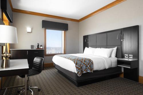 a hotel room with a bed and a desk at voco The Tiger Hotel, Columbia, MO by IHG in Columbia