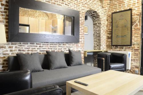salon z kanapą i ceglaną ścianą w obiekcie Cozy Loft - Royal Palace w Madrycie
